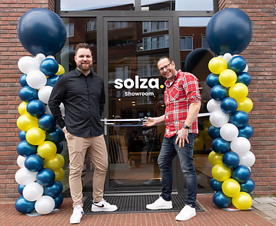 Dennis Mulder opent Vloerenwinkel Solza, met links naast hem Jorik van der Heide. Dennis Mulder pent Solza met links Jorik van der Heide
